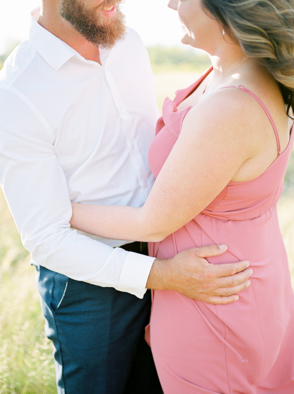 Fine Art Wedding Photographer Esther Funk Photography | A Semi Formal Birds Hill Provincial Park Engagement Session | A couple standing in a field holding on to each other | She is wearing a rose coloured dress