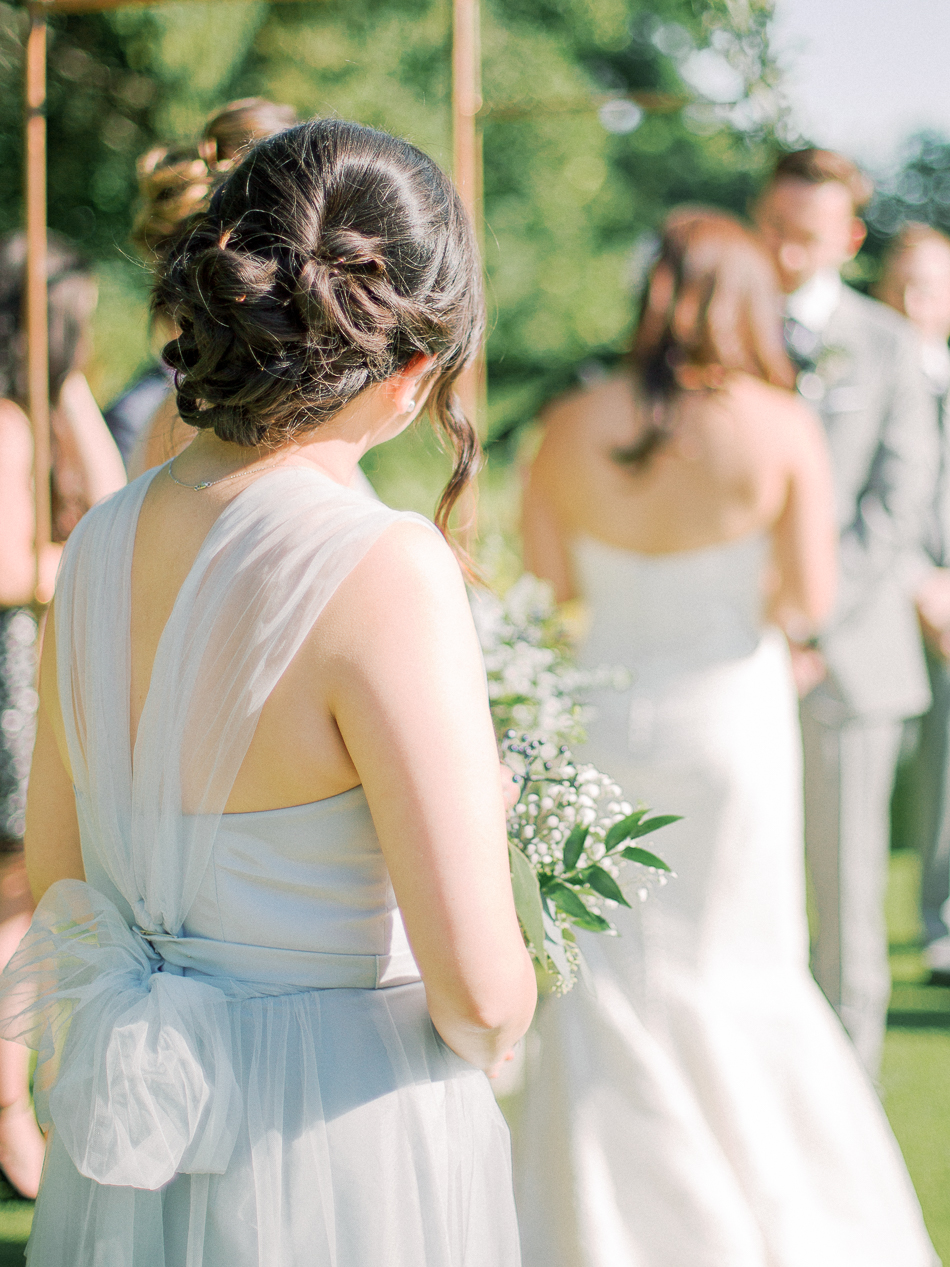 Minimalist Modern Winnipeg Wedding | Photographed by Esther Funk Photography | Winnipeg Country Club Wedding | St. Charles Country Club Wedding | Ceremony Decor | Minimal Modern Ceremony Style | Outdoor Summer Wedding | Copper Ceremony Arch | Dusty blue bridesmaids dresses by David's Bridal | Romantic low updo