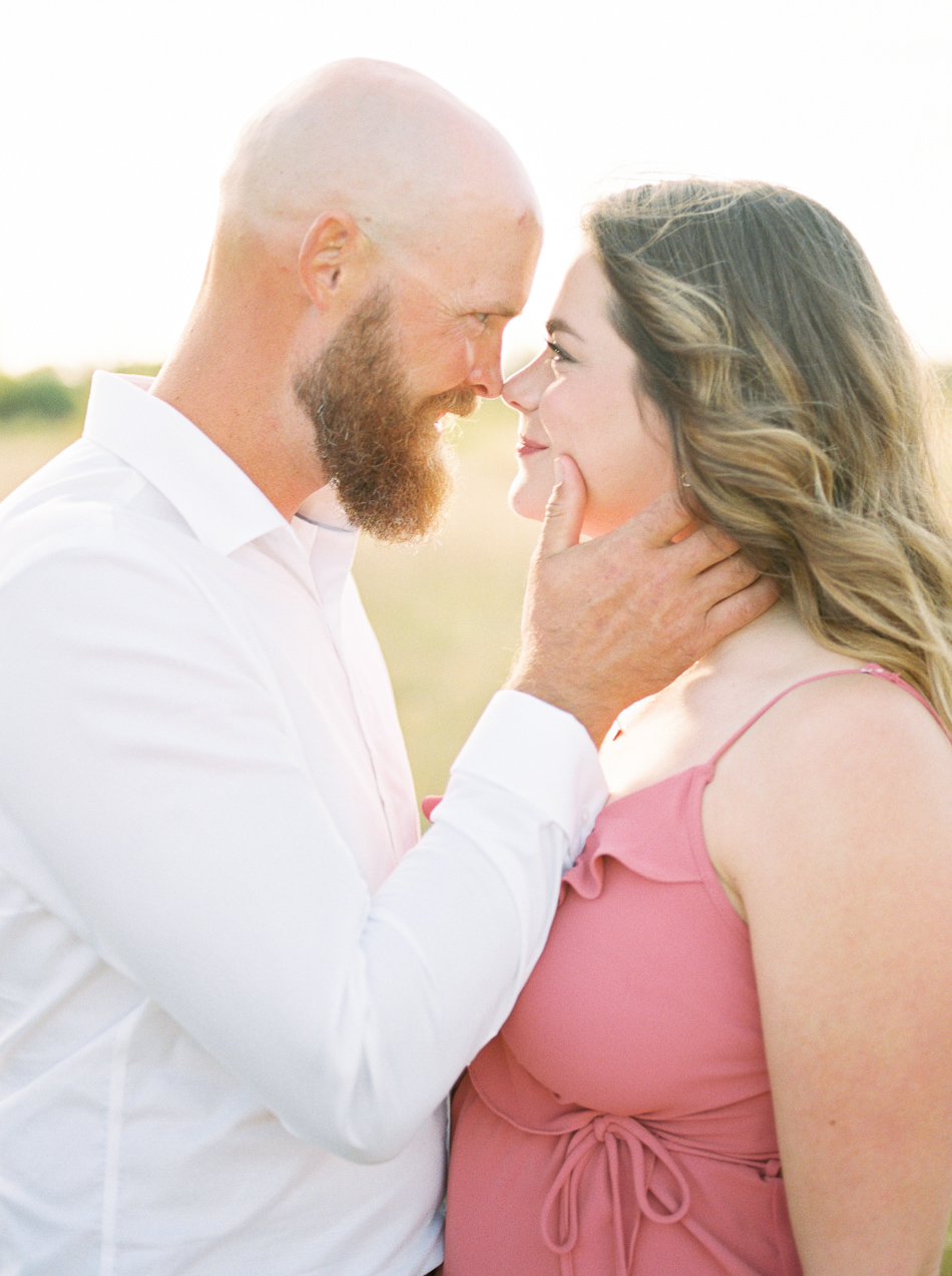 Fine Art Wedding Photographer Esther Funk Photography | A Birds Hill Provincial Park engagement session | A couple looking into each other's eyes | She is wearing a rose coloured dress